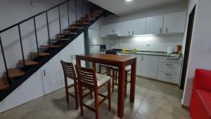 a kitchen with a table and chairs and a staircase at Caribe in Concepción del Uruguay