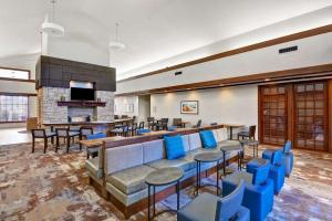 a hotel lobby with a bar and blue chairs at Homewood Suites by Hilton Kansas City/Overland Park in Overland Park