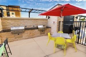 a patio with a table and chairs and an umbrella at Home2 Suites By Hilton Roseville Sacramento in Roseville