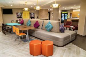 un soggiorno con divano, tavolo e sedie di Home2 Suites By Hilton Roseville Sacramento a Roseville