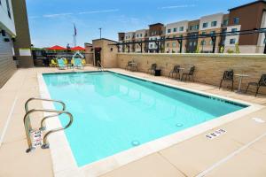 a swimming pool at a hotel with tables and chairs at Home2 Suites By Hilton Roseville Sacramento in Roseville