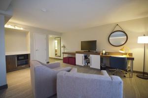 a living room with a couch and a mirror at Hampton Inn Salem East - Electric Road in Salem