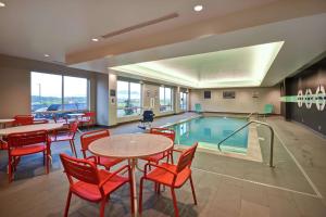 una piscina con tavoli e sedie di Tru By Hilton Pigeon Forge a Pigeon Forge