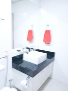 Baño blanco con lavabo y espejo en Recanto do sossego, en Nova Lima
