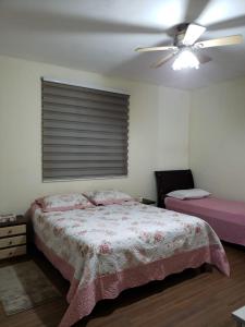 1 dormitorio con 1 cama y ventilador de techo en Recanto do sossego, en Nova Lima