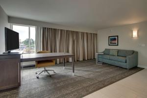 Hampton Inn-Pawtucket, RI في بوتكيت: غرفة في الفندق مع مكتب وأريكة