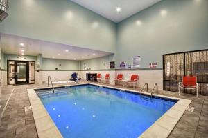 a large swimming pool in a hospital room with red chairs at Homewood Suites by Hilton Novi Detroit in Novi