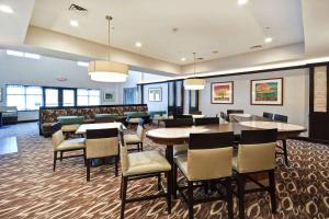 a restaurant with tables and chairs and a bar at Homewood Suites by Hilton Novi Detroit in Novi
