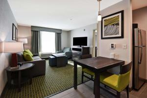 a living room with a couch and a table in a hotel room at Homewood Suites by Hilton Novi Detroit in Novi