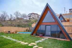 una pequeña casa con un techo triangular en un patio en Greenworldbungalov2, en Sapanca