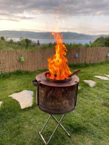 a barbecue grill with fire in a yard at Greenworldbungalov2 in Sapanca