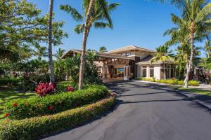 a house with palm trees and a driveway at Hilton Grand Vacations Club Kohala Suites Waikoloa in Waikoloa