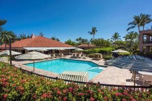 una piscina con sombrillas y un complejo en Hilton Grand Vacations Club Kohala Suites Waikoloa en Waikoloa