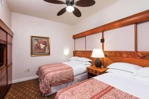 a hotel room with two beds and a ceiling fan at Hilton Grand Vacations Club Kohala Suites Waikoloa in Waikoloa