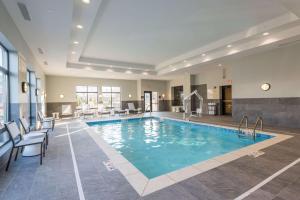 Hampton Inn & Suites West Lafayette, In في ويست لافاييت: وجود مسبح في غرفة الفندق مع الكراسي