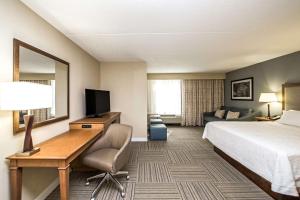 a hotel room with a bed and a desk with a computer at Hampton Inn Philadelphia-Airport in Philadelphia