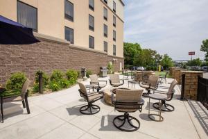 un patio avec des chaises et des tables en face d'un bâtiment dans l'établissement Hampton Inn & Suites - Pittsburgh/Harmarville, PA, à Harmarville