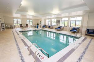 a large swimming pool in a large room with chairs at Hampton Inn & Suites - Pittsburgh/Harmarville, PA in Harmarville