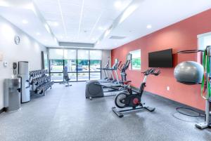 a gym with cardio equipment and a red wall at Home2 Suites By Hilton Daphne Spanish Fort in Daphne