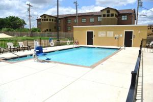 una piscina en un complejo de apartamentos con un edificio en Hampton Inn Carrizo Springs, en Carrizo Springs