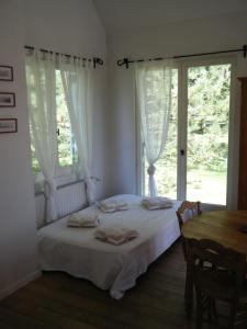 een slaapkamer met een bed en een tafel en ramen bij La Source in Condette