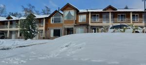 a pile of snow in front of a house at Hostería Las Semillas in Villa La Angostura