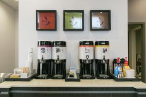 un mostrador con una fila de tazas de café. en Hampton Inn & Suites Stroud en Stroud
