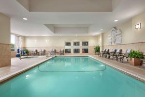 - une piscine dans une chambre d'hôtel avec des chaises et des tables dans l'établissement Hampton Inn & Suites Washington-Dulles International Airport, à Sterling