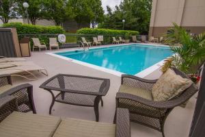 a swimming pool with wicker chairs and a table and chairs at Hampton Inn Winchester-University/ Mall in Winchester