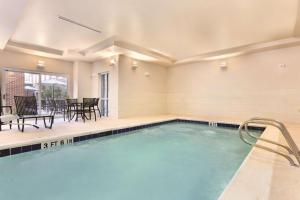 a pool with chairs and a table in a building at Homewood Suites Atlanta Airport North in Atlanta