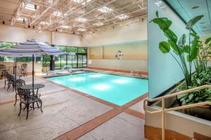a pool with a table and chairs and an umbrella at DoubleTree Suites by Hilton Seattle Airport/Southcenter in Tukwila