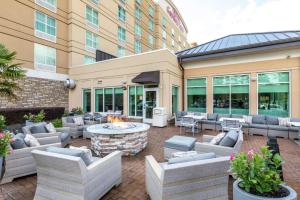 eine Terrasse mit Sofas und einer Feuerstelle vor einem Gebäude in der Unterkunft Hilton Garden Inn Atlanta Airport North in Atlanta