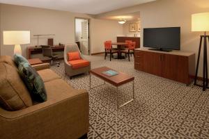 DoubleTree Suites by Hilton Seattle Airport/Southcenter في توكويلا: غرفة معيشة مع أريكة وتلفزيون بشاشة مسطحة