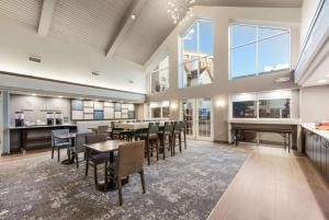 a dining room with tables and chairs and a fireplace at Hampton Inn & Suites Chicago-Hoffman Estates in Hoffman Estates