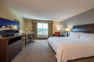 a hotel room with a bed and a desk at Hilton Garden Inn Atlanta Airport North in Atlanta