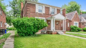 una casa de ladrillo con un patio de hierba delante de ella en Pleasant Family Stay in Home near Downtown Detroit, en Detroit