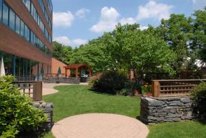 a walkway next to a building with a garden at Hilton Long Island/Huntington in Melville