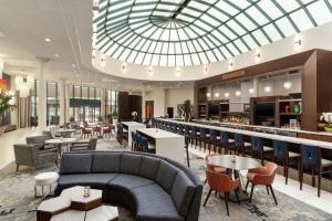 eine Lobby mit Sofas, Tischen und einer Bar in der Unterkunft Hilton Long Island/Huntington in Melville