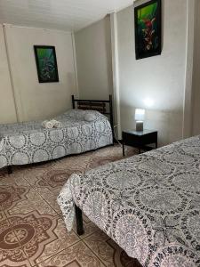 um quarto de hotel com duas camas e uma mesa em Casona Tica Linda em Sarapiquí