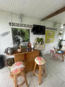 a room with two chairs and a table and a tv at La rose in Le Robert