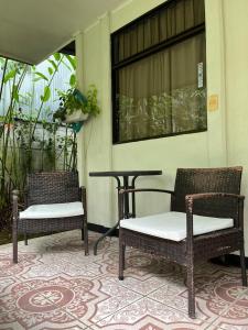 two wicker chairs and a table on a porch at Casona Tica Linda in Sarapiquí