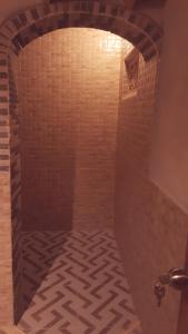 a bathroom with a shower with a brick wall at Pondok Indah Bungalows Tetebatu in Tetebatu