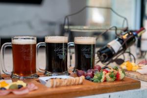 dos vasos de cerveza y algo de fruta en una tabla de cortar en Mountainside Beer Spa & Lodge en Baños