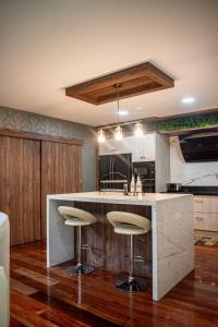 a kitchen with a large island with bar stools at Mountainside Beer Spa & Lodge in Baños