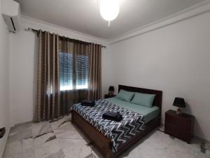 a bedroom with a bed and a large window at Appartement à louer à Tlemcen in Tlemcen