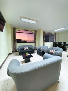 a large living room with blue couches and a table at Blue Horizon, Galápagos in Puerto Baquerizo Moreno