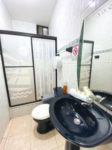 a bathroom with a black sink and a toilet at Blue Horizon, Galápagos in Puerto Baquerizo Moreno