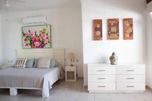 1 dormitorio con 1 cama, vestidor y una pintura en Casa Faro en Troncones