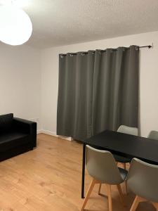 a living room with a black table and chairs at Cozy house with free parking in Manchester