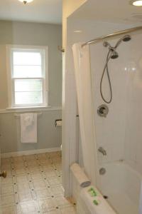 uma casa de banho com um chuveiro e uma janela em Niagara Riverview Closest to Falls, Free Breakfast Delivered Daily em Cataratas do Niágara